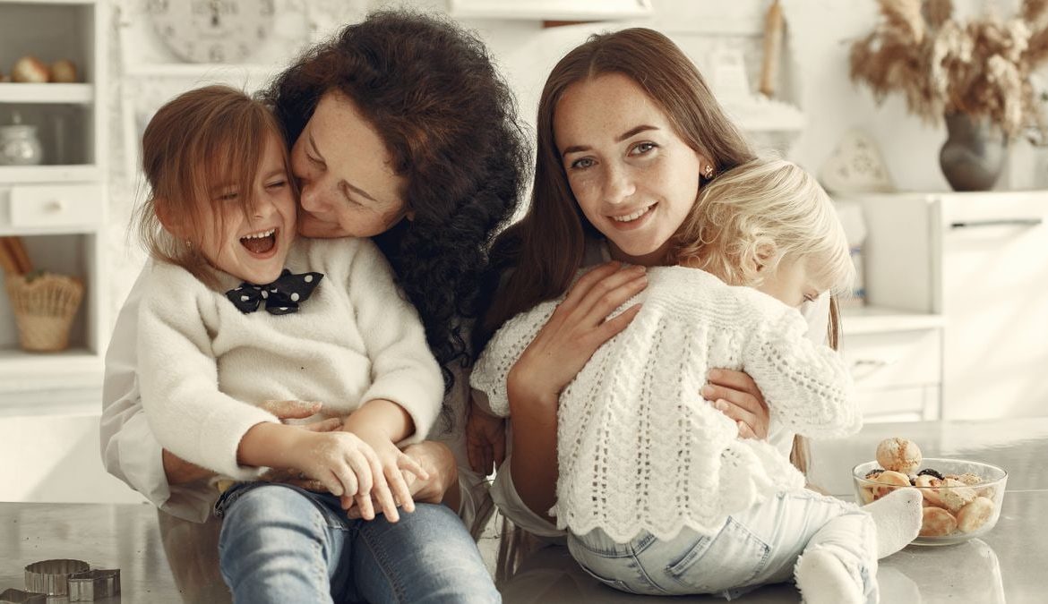 A joyful family gathering in a cozy kitchen with three generations bonded in happiness.